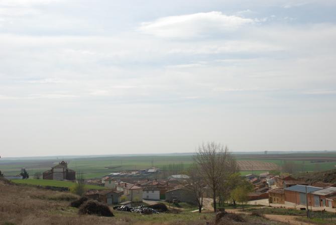 Vista panorámica de Ledigos entre campos de cereal, con la iglesia al fondo